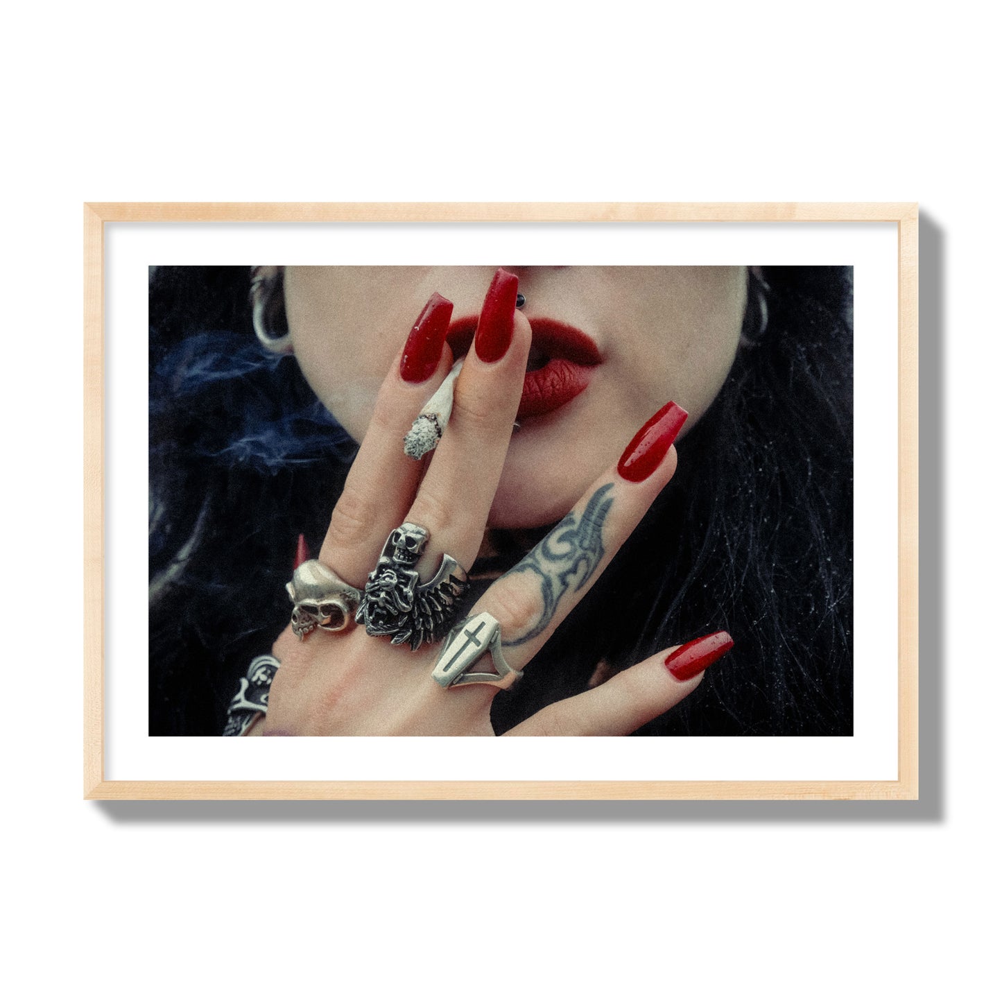 Fine art close-up photograph of a woman smoking, her hands covered with chunky rings and tattoos. Archival pigment print, giant size, natural wood frame.