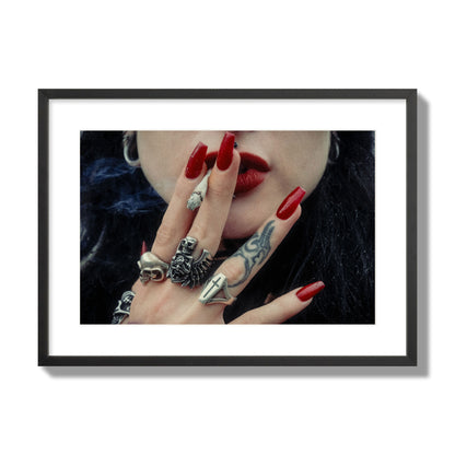 Fine art close-up photograph of a woman smoking, her hands covered with chunky rings and tattoos. Archival pigment print, large size, black frame.