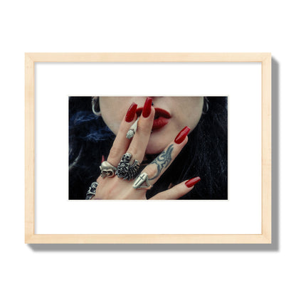 Fine art close-up photograph of a woman smoking, her hands covered with chunky rings and tattoos. Archival pigment print, small size, natural wood frame.
