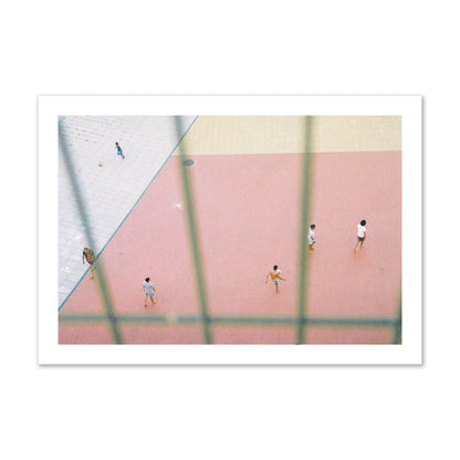 Fine art street photograph of a geometric outdoor scene in Portugal with people playing soccer on a pink field, archival pigment print, collector size, print.