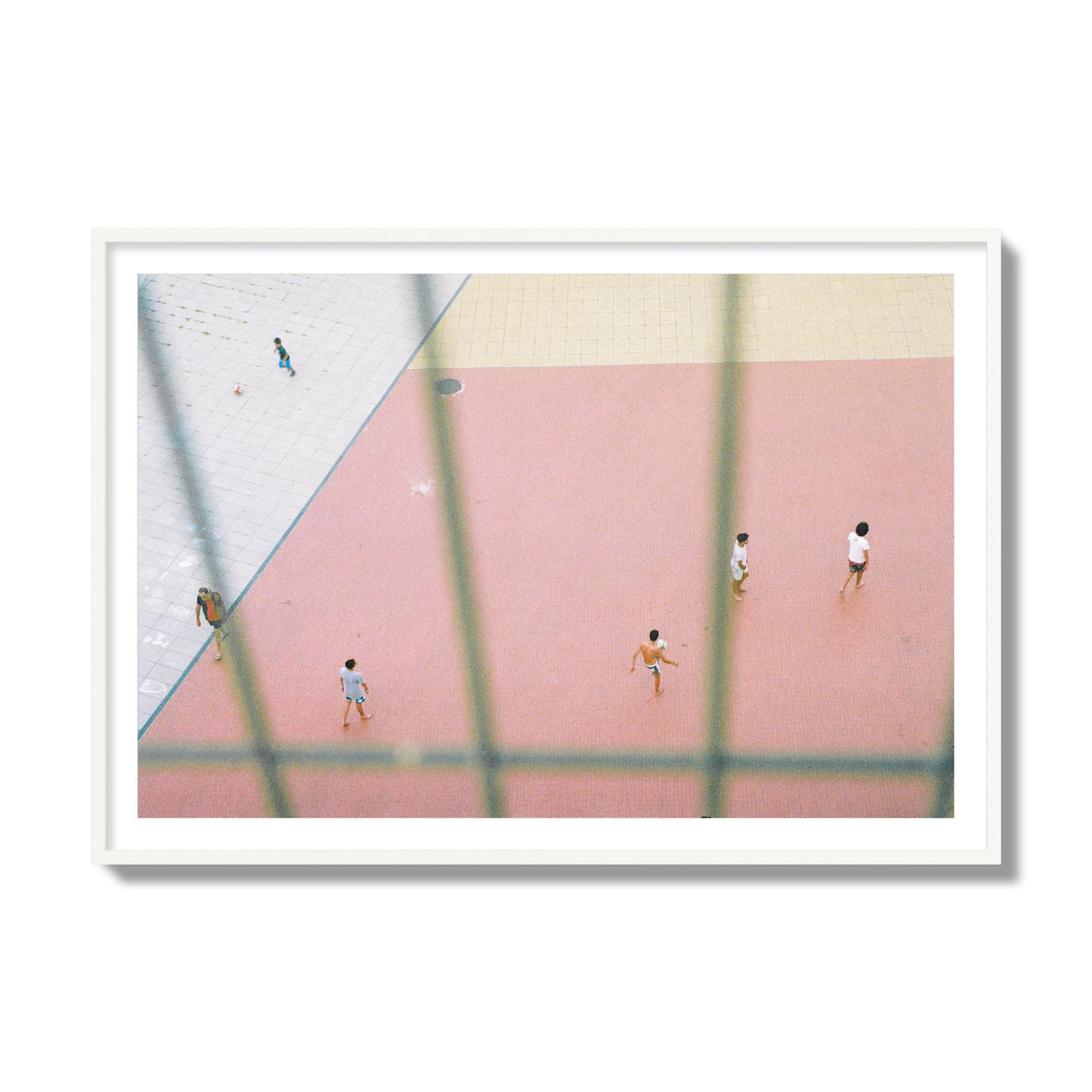 Fine art street photograph of a geometric outdoor scene in Portugal with people playing soccer on a pink field, archival pigment print, collector size, white frame.