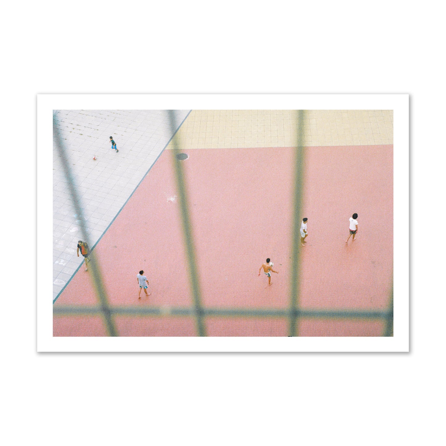 Fine art street photograph of a geometric outdoor scene in Portugal with people playing soccer on a pink field, archival pigment print, gallery size, print.
