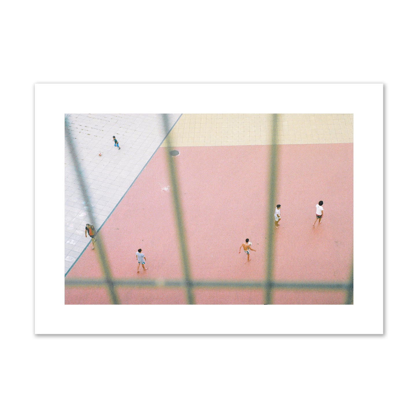 Fine art street photograph of a geometric outdoor scene in Portugal with people playing soccer on a pink field, archival pigment print, giant size, print.