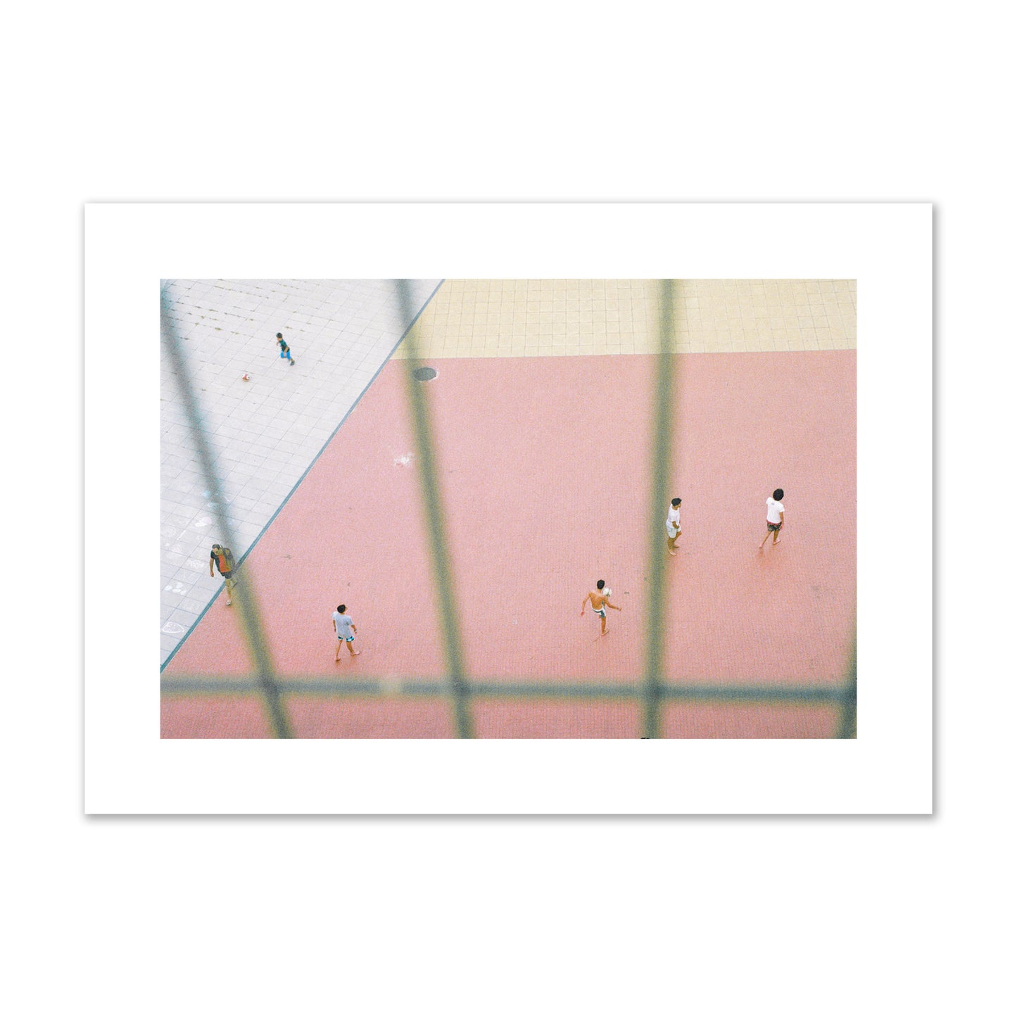 Fine art street photograph of a geometric outdoor scene in Portugal with people playing soccer on a pink field, archival pigment print, large size, print.