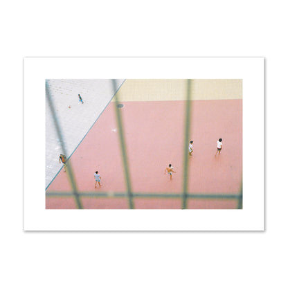 Fine art street photograph of a geometric outdoor scene in Portugal with people playing soccer on a pink field, archival pigment print, large size, print.