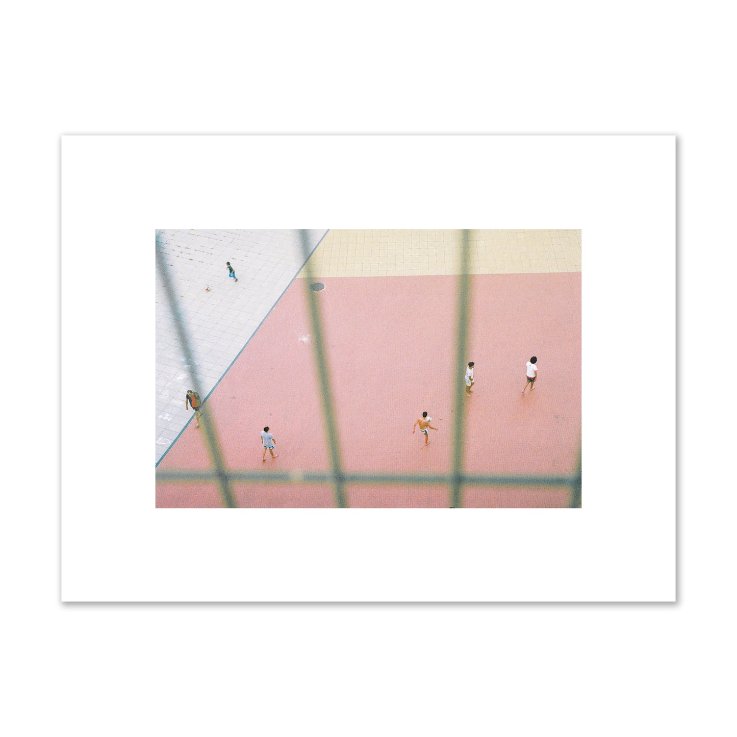 Fine art street photograph of a geometric outdoor scene in Portugal with people playing soccer on a pink field, archival pigment print, small size, print.