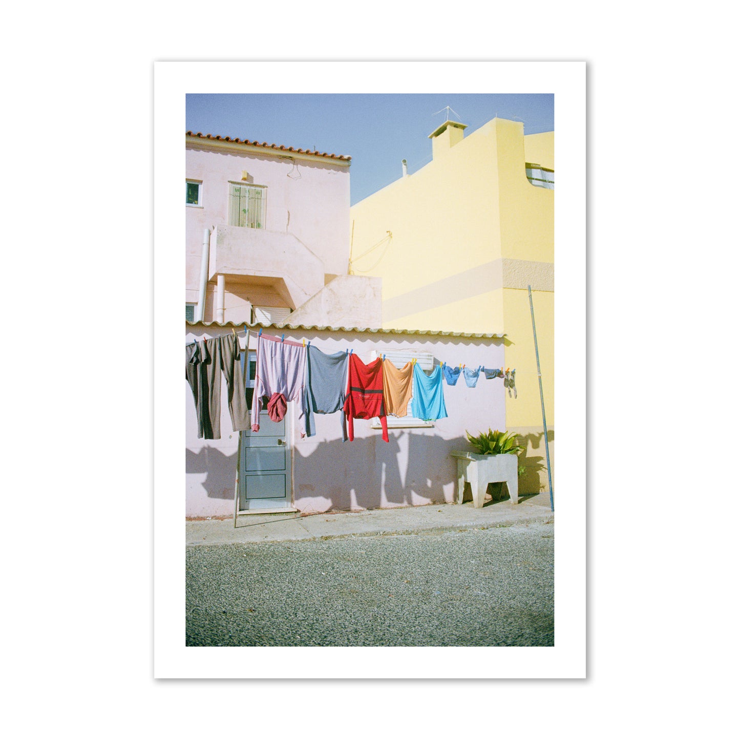 Fine art street photograph of a colorful outdoor scene in Portugal with clothes hanging on a line, archival pigment print, collector size, print.