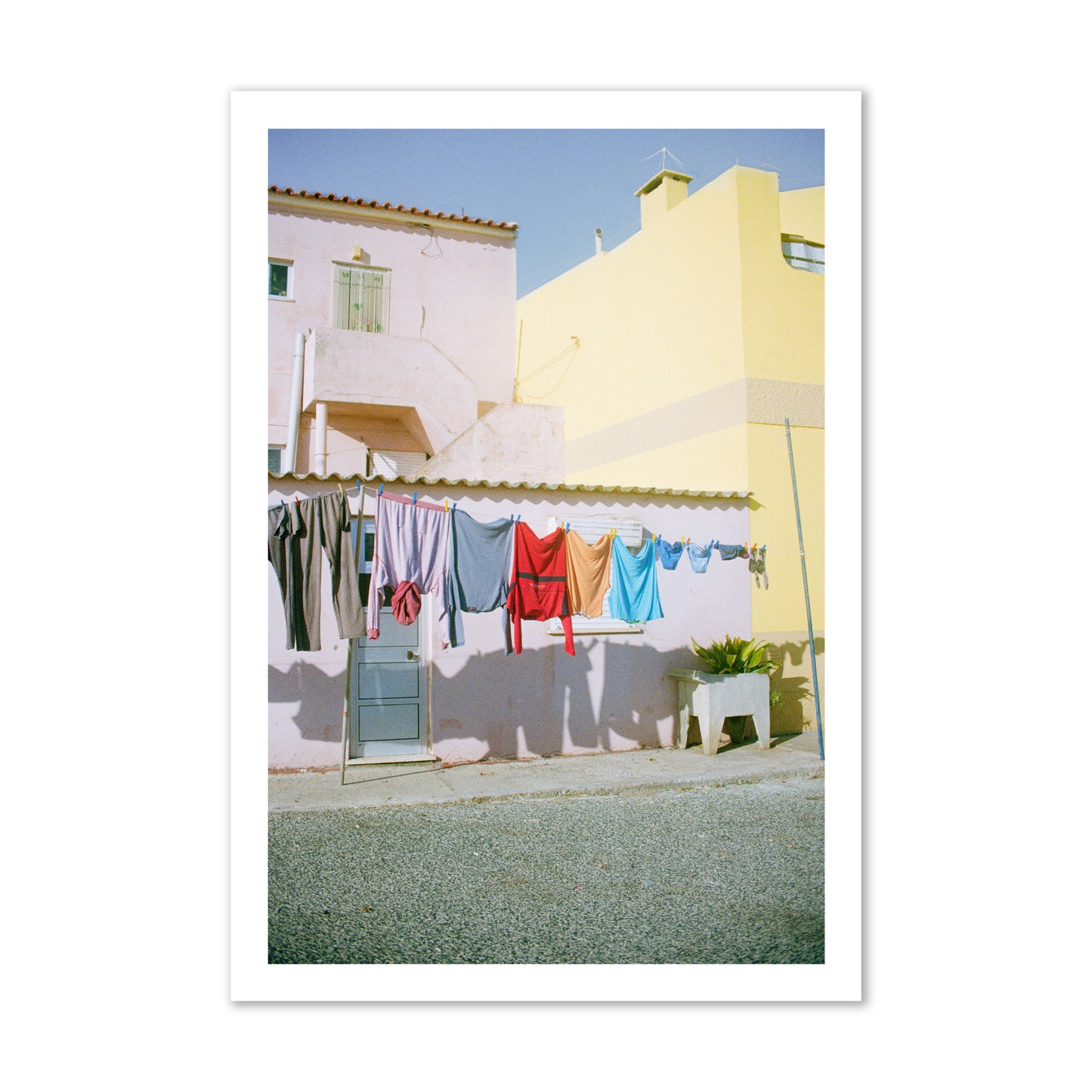 Fine art street photograph of a colorful outdoor scene in Portugal with clothes hanging on a line, archival pigment print, gallery size, print.