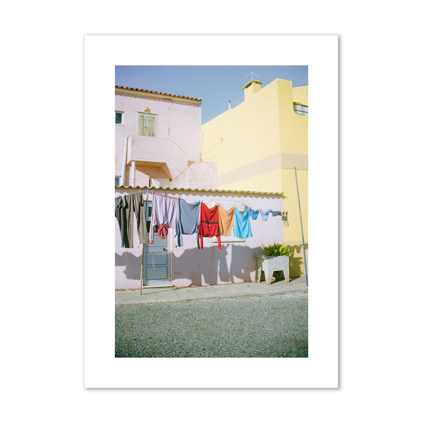 Fine art street photograph of a colorful outdoor scene in Portugal with clothes hanging on a line, archival pigment print, giant size, print.