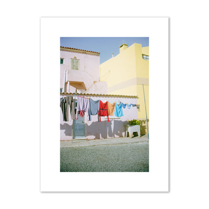 Fine art street photograph of a colorful outdoor scene in Portugal with clothes hanging on a line, archival pigment print, medium size, print.