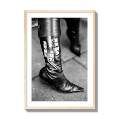 Fine art black and white photo of a woman's black leather boot with the words Punk is Not Dead, archival pigment print, giant size, natural wood frame.