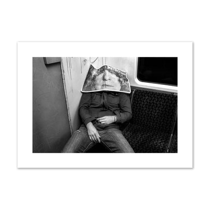Fine art photograph of a man asleep on the subway with a newspaper covering their face, archival pigment print, giant size, unframed.