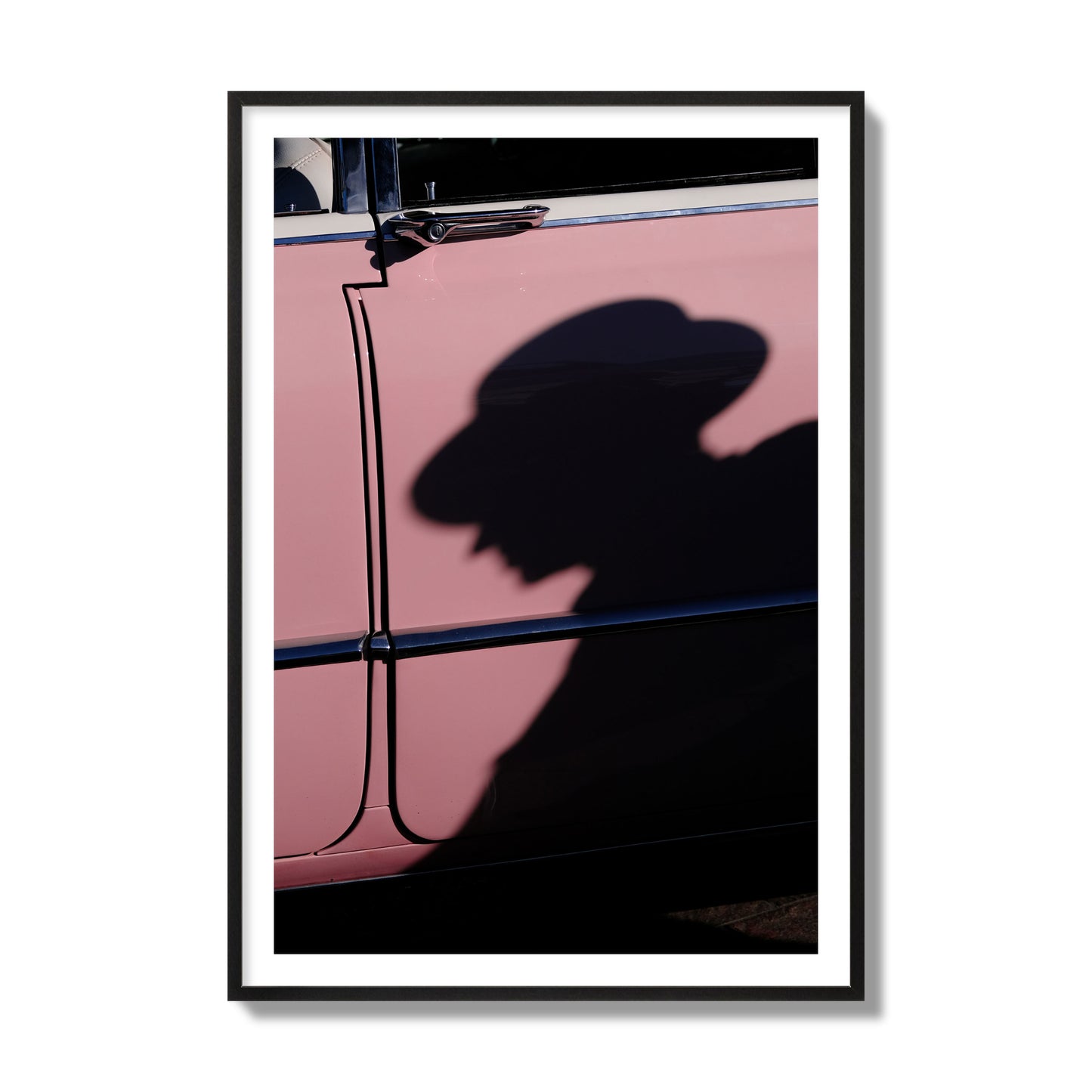 Fine art photograph of a man's shadow cast on a pink retro car, archival pigment print, collector size, black frame.