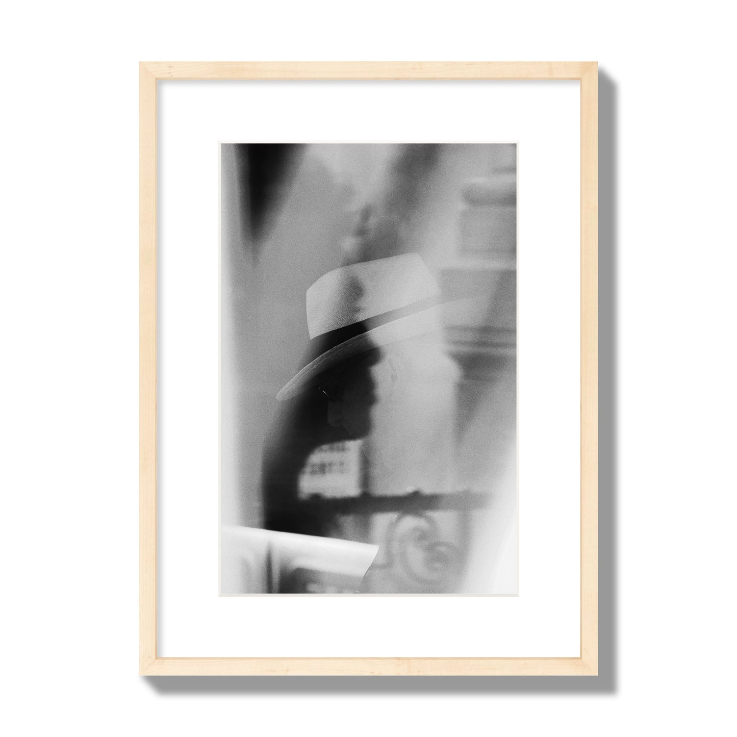 Fine art black and white photograph of multiple faces reflecting in a window, archival pigment print, medium size, natural wood frame.