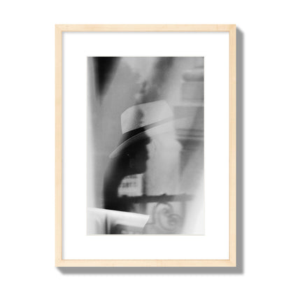 Fine art black and white photograph of multiple faces reflecting in a window, archival pigment print, medium size, natural wood frame.