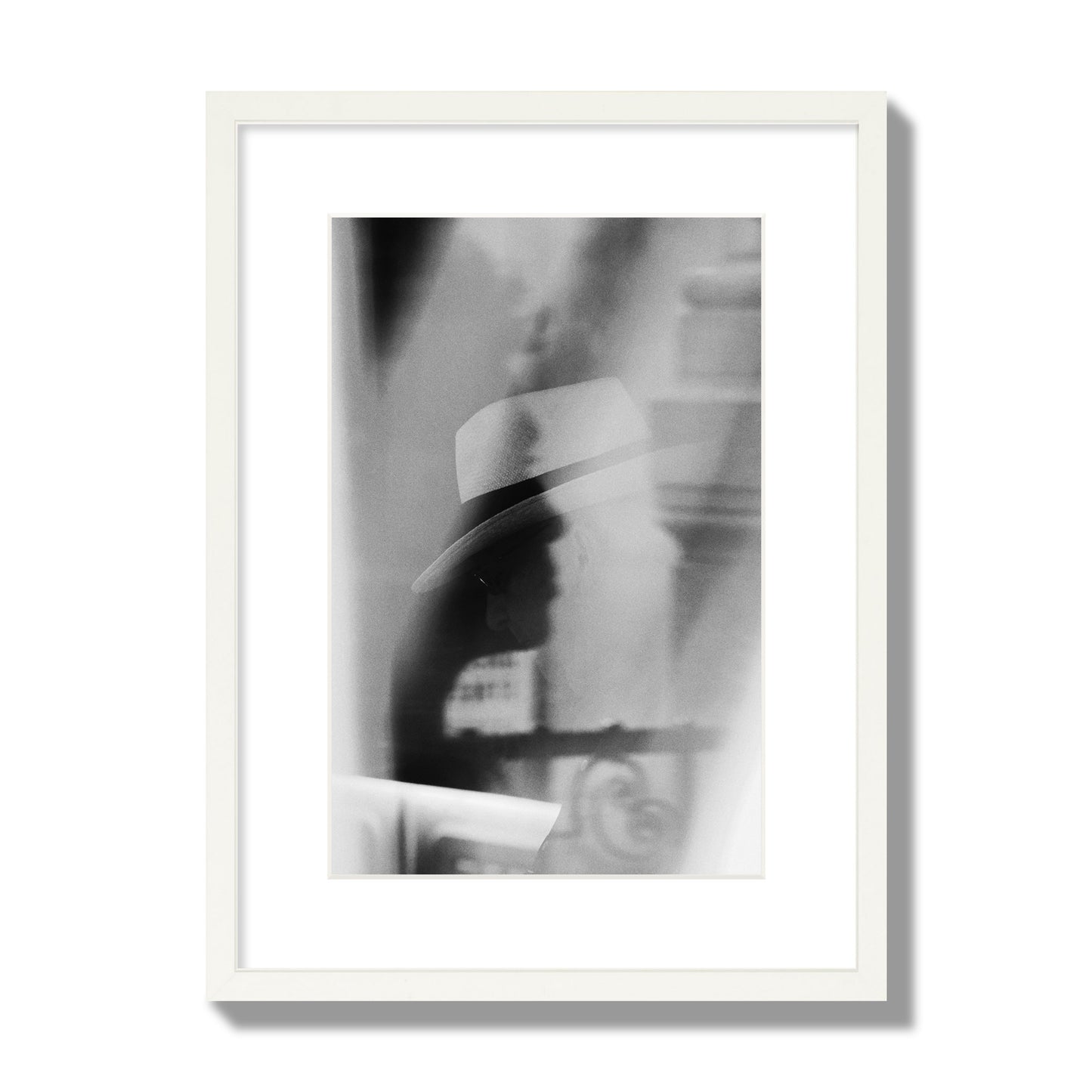 Fine art black and white photograph of multiple faces reflecting in a window, archival pigment print, medium size, white frame.