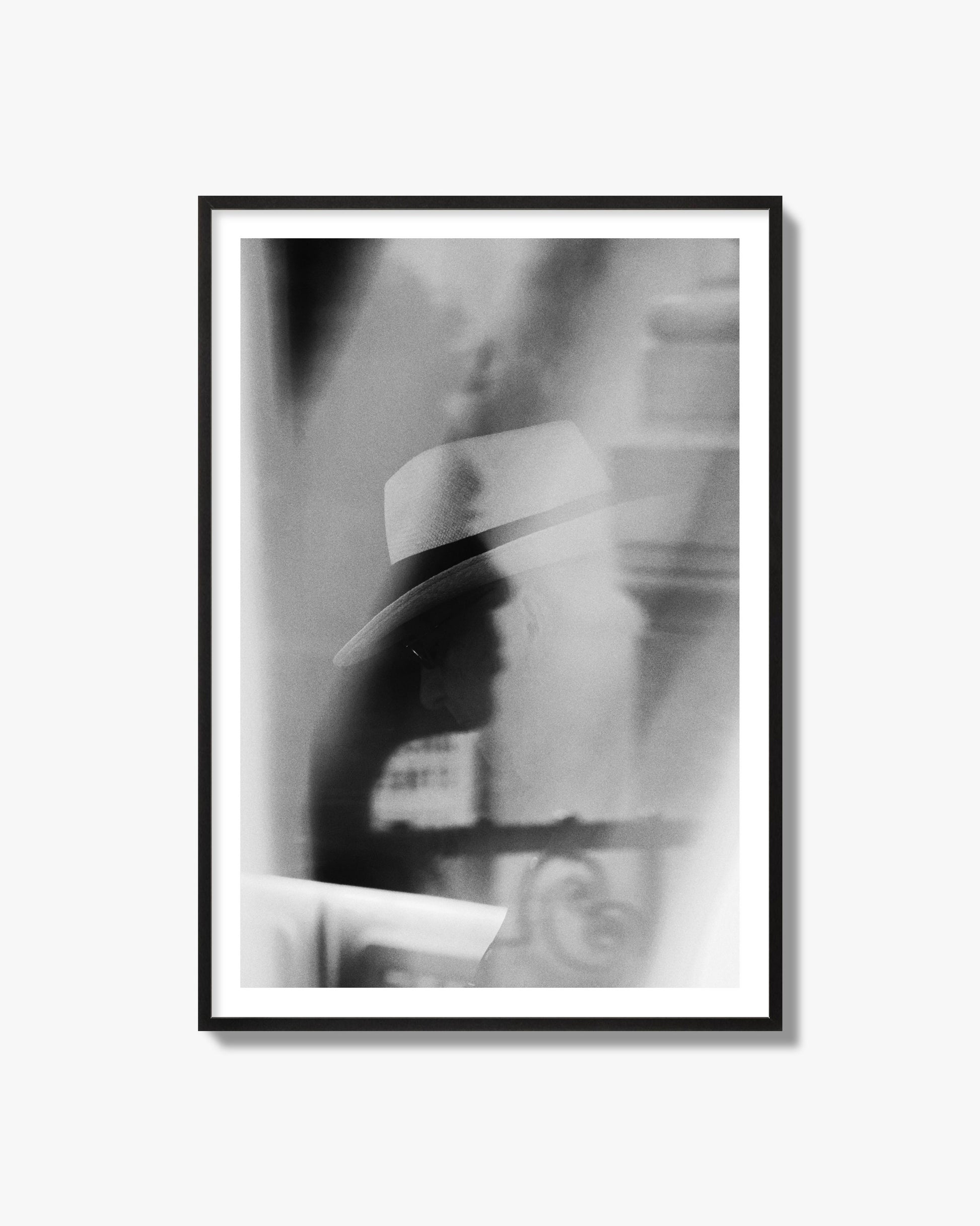 Fine art black and white photograph of multiple faces reflecting in a window, archival pigment print, black frame.