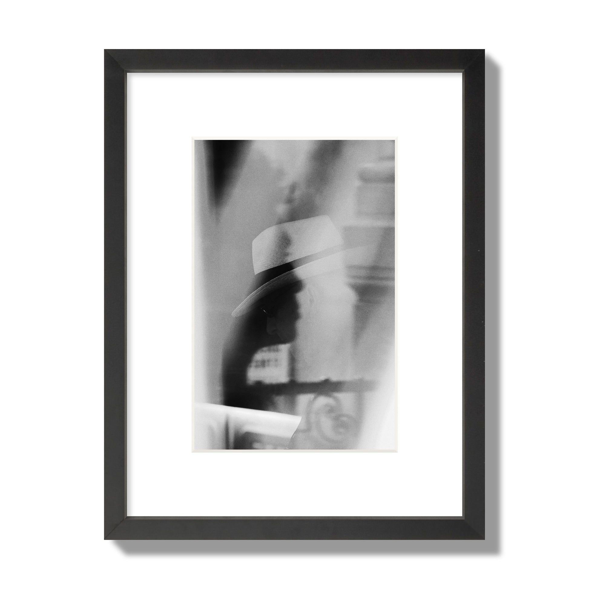 Fine art black and white photograph of multiple faces reflecting in a window, archival pigment print, small size, black frame.