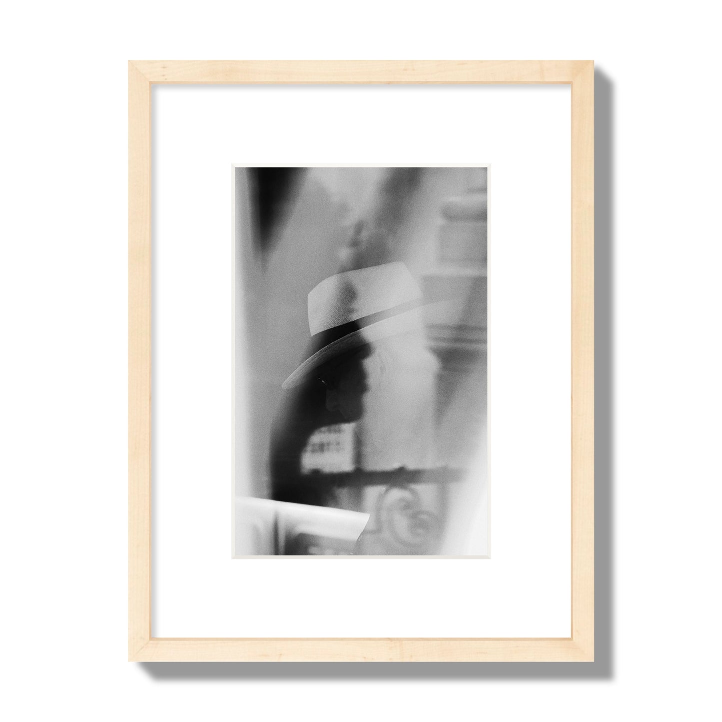 Fine art black and white photograph of multiple faces reflecting in a window, archival pigment print, small size, natural wood frame.
