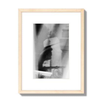 Fine art black and white photograph of multiple faces reflecting in a window, archival pigment print, small size, natural wood frame.