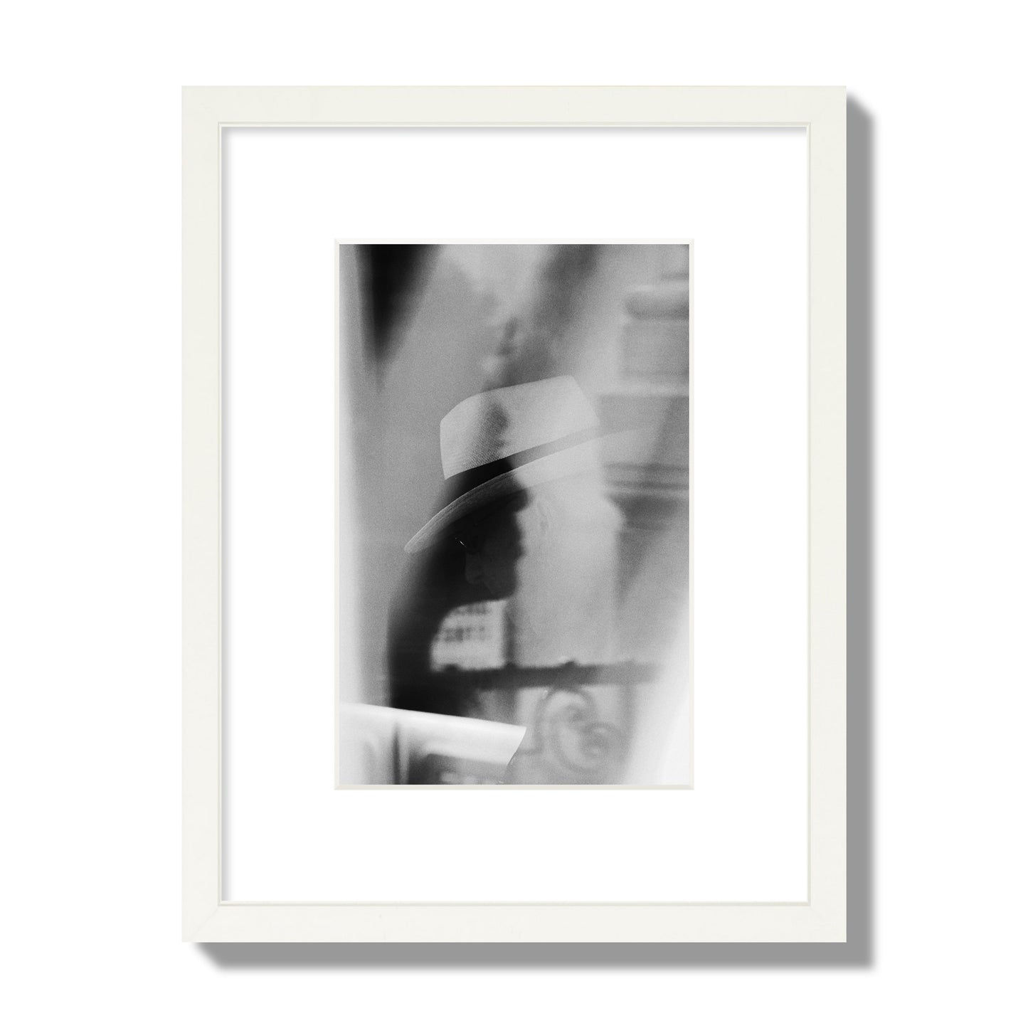 Fine art black and white photograph of multiple faces reflecting in a window, archival pigment print, small size, white frame.