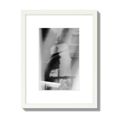 Fine art black and white photograph of multiple faces reflecting in a window, archival pigment print, small size, white frame.
