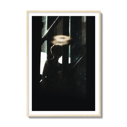 Fine art photograph of a silhouetted woman with a glowing halo light above her head, archival pigment print, collector size, natural wood frame.