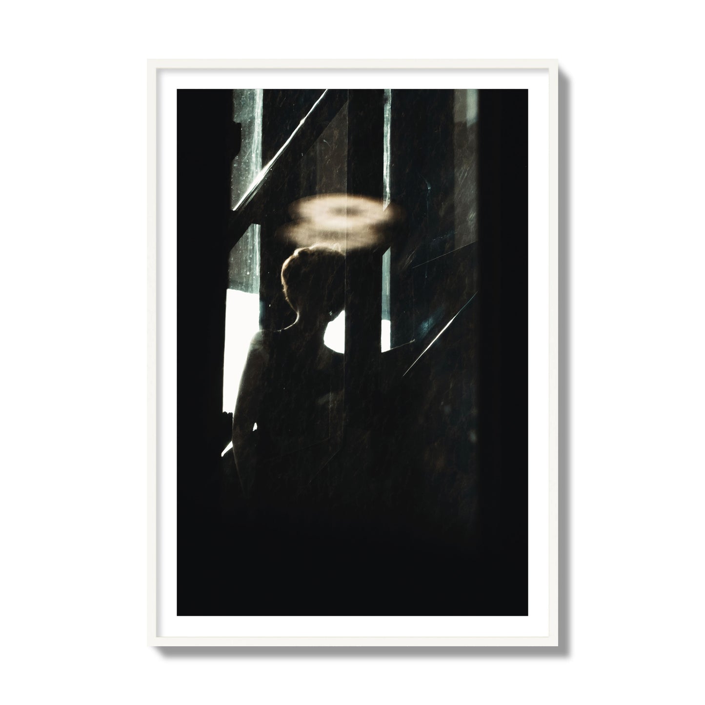 Fine art photograph of a silhouetted woman with a glowing halo light above her head, archival pigment print, collector size, white frame.