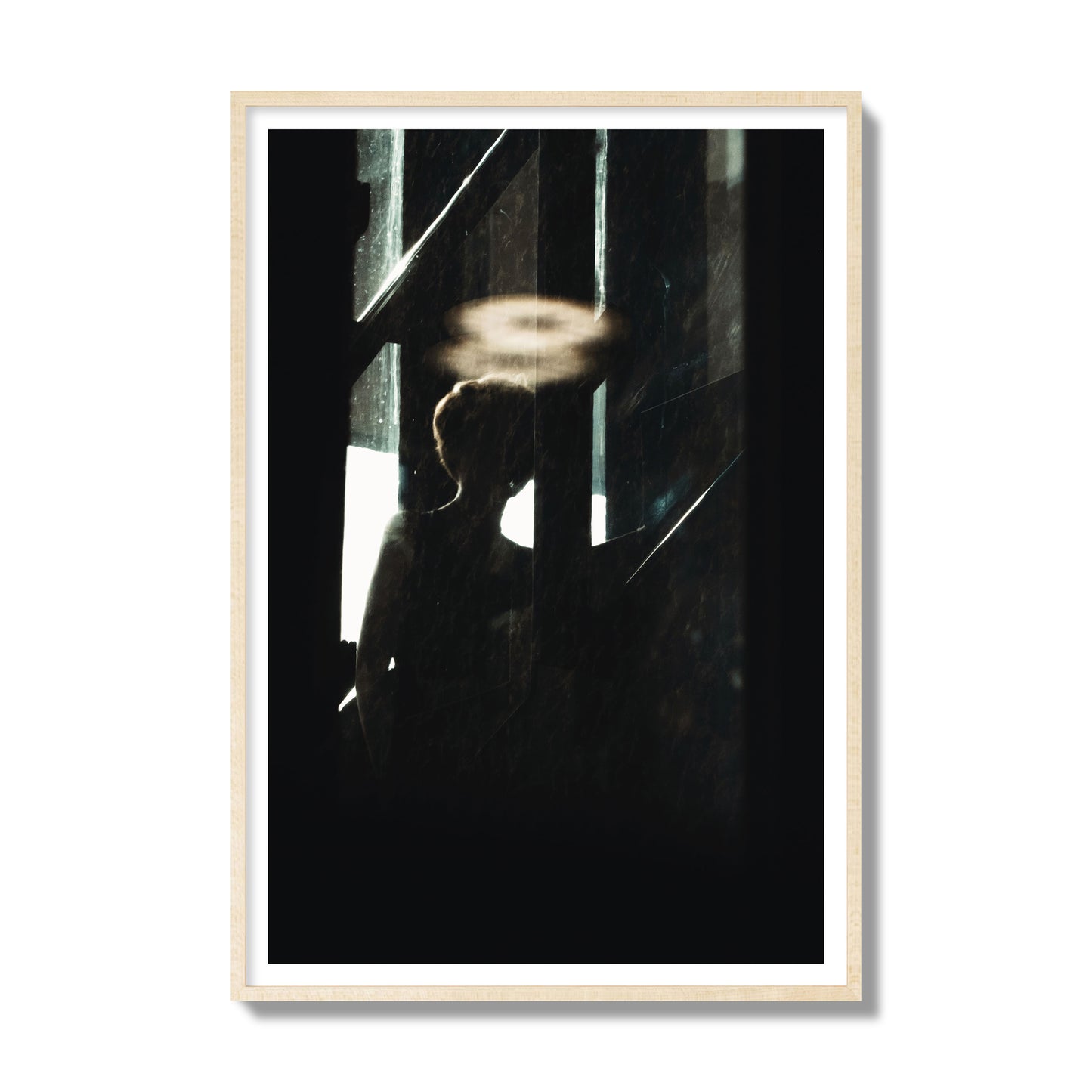 Fine art photograph of a silhouetted woman with a glowing halo light above her head, archival pigment print, gallery size, natural wood frame.