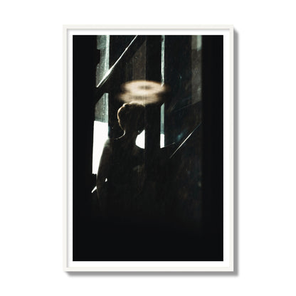 Fine art photograph of a silhouetted woman with a glowing halo light above her head, archival pigment print, gallery size, white frame.