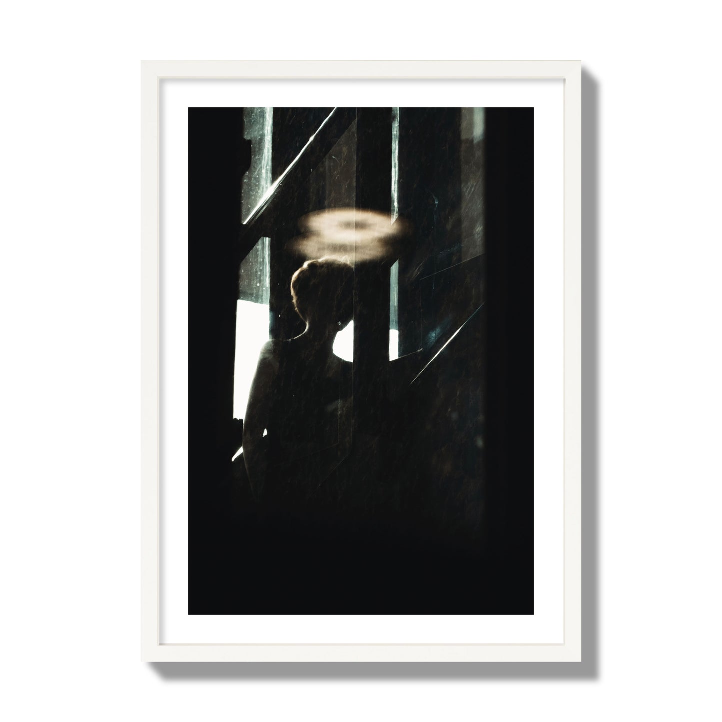 Fine art photograph of a silhouetted woman with a glowing halo light above her head, archival pigment print, giant size, white frame.