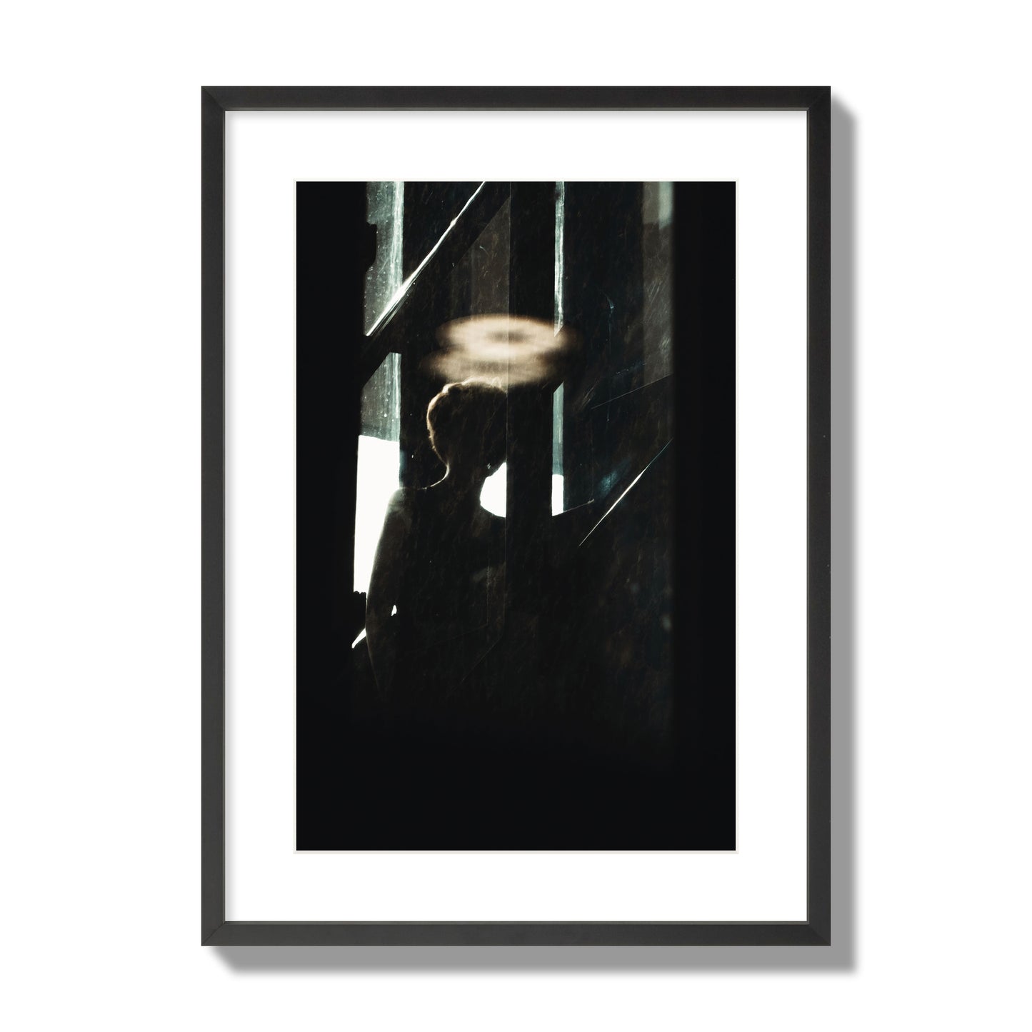 Fine art photograph of a silhouetted woman with a glowing halo light above her head, archival pigment print, large size, black frame.