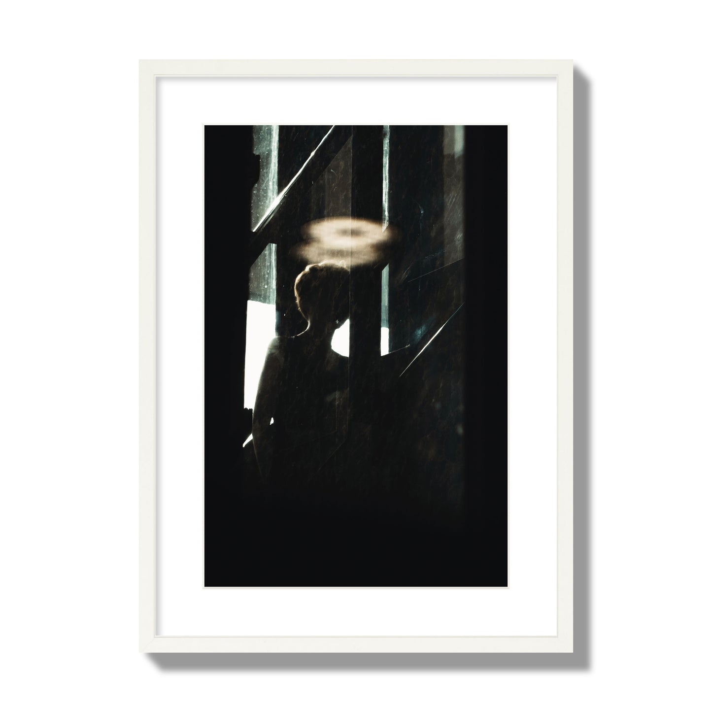 Fine art photograph of a silhouetted woman with a glowing halo light above her head, archival pigment print, large size, white frame.