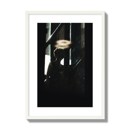 Fine art photograph of a silhouetted woman with a glowing halo light above her head, archival pigment print, large size, white frame.