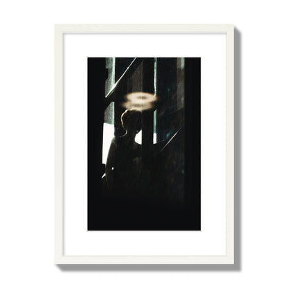 Fine art photograph of a silhouetted woman with a glowing halo light above her head, archival pigment print, medium size, white frame.