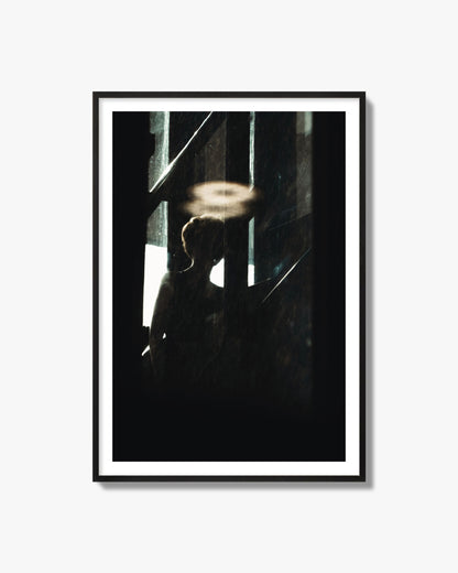 Fine art photograph of a silhouetted woman with a glowing halo light above her head, archival pigment print, black frame.