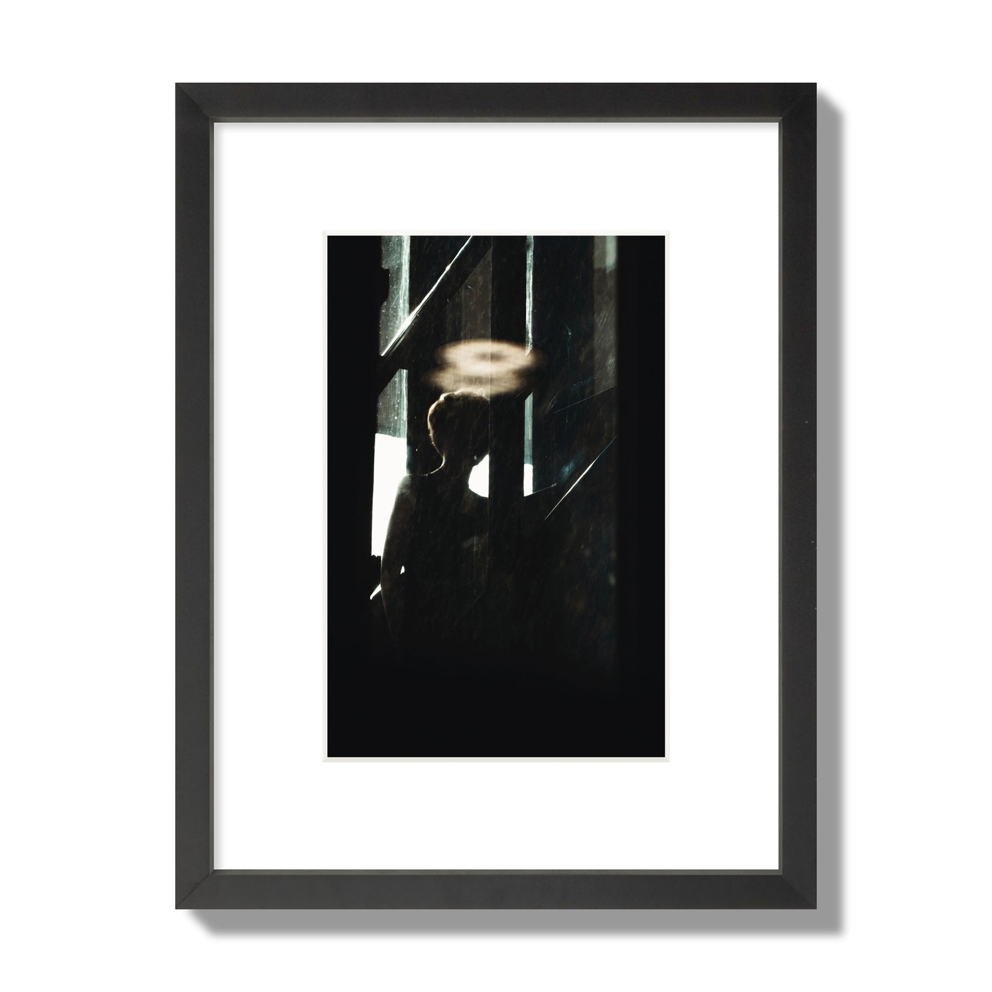 Fine art photograph of a silhouetted woman with a glowing halo light above her head, archival pigment print, small size, black frame.
