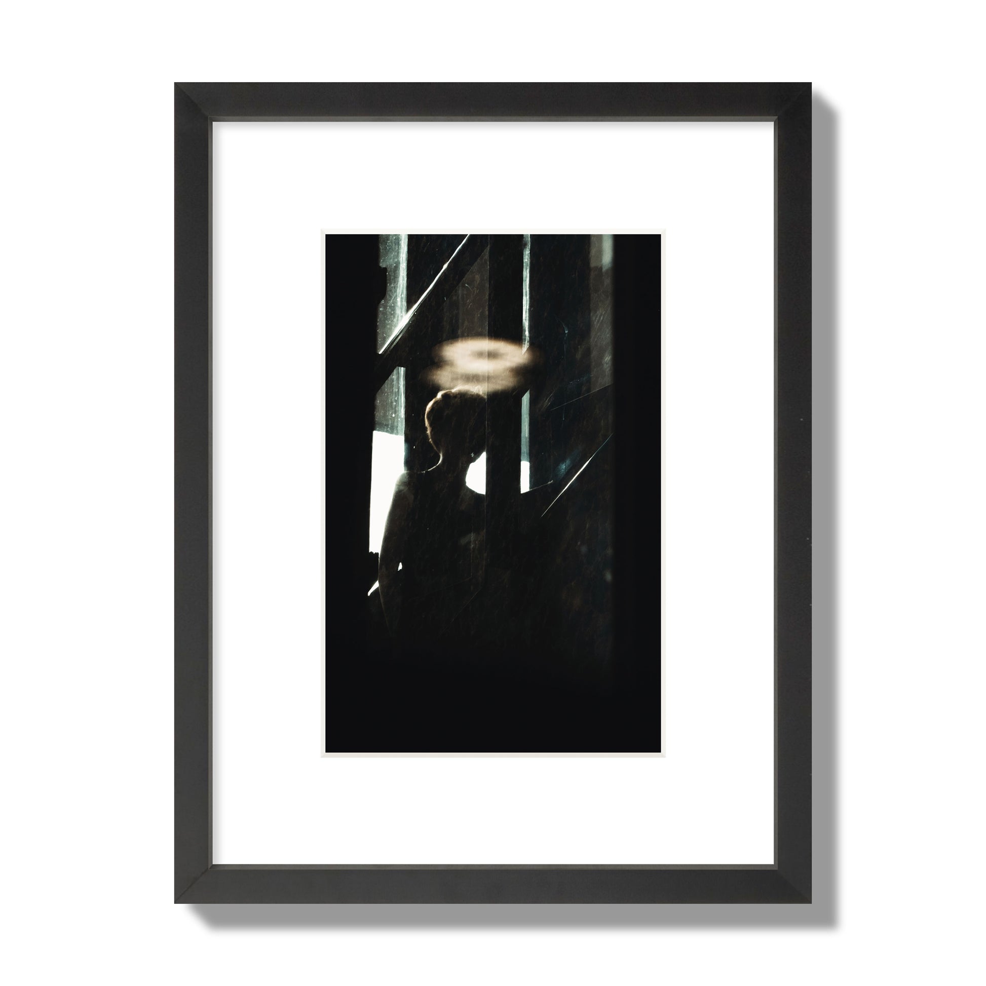 Fine art photograph of a silhouetted woman with a glowing halo light above her head, archival pigment print, small size, black frame.