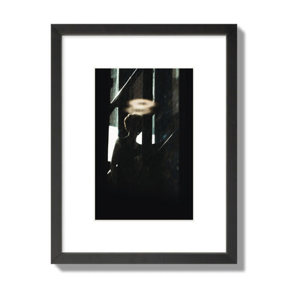 Fine art photograph of a silhouetted woman with a glowing halo light above her head, archival pigment print, small size, black frame.