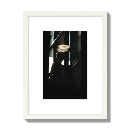 Fine art photograph of a silhouetted woman with a glowing halo light above her head, archival pigment print, small size, white frame.