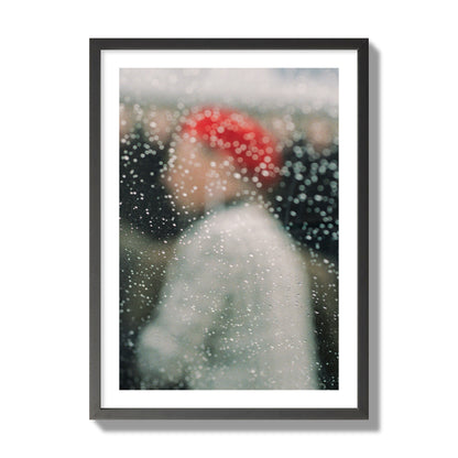 Fine art photograph of a woman with a red hat through raindrops on a window, archival pigment print, giant size, black frame.