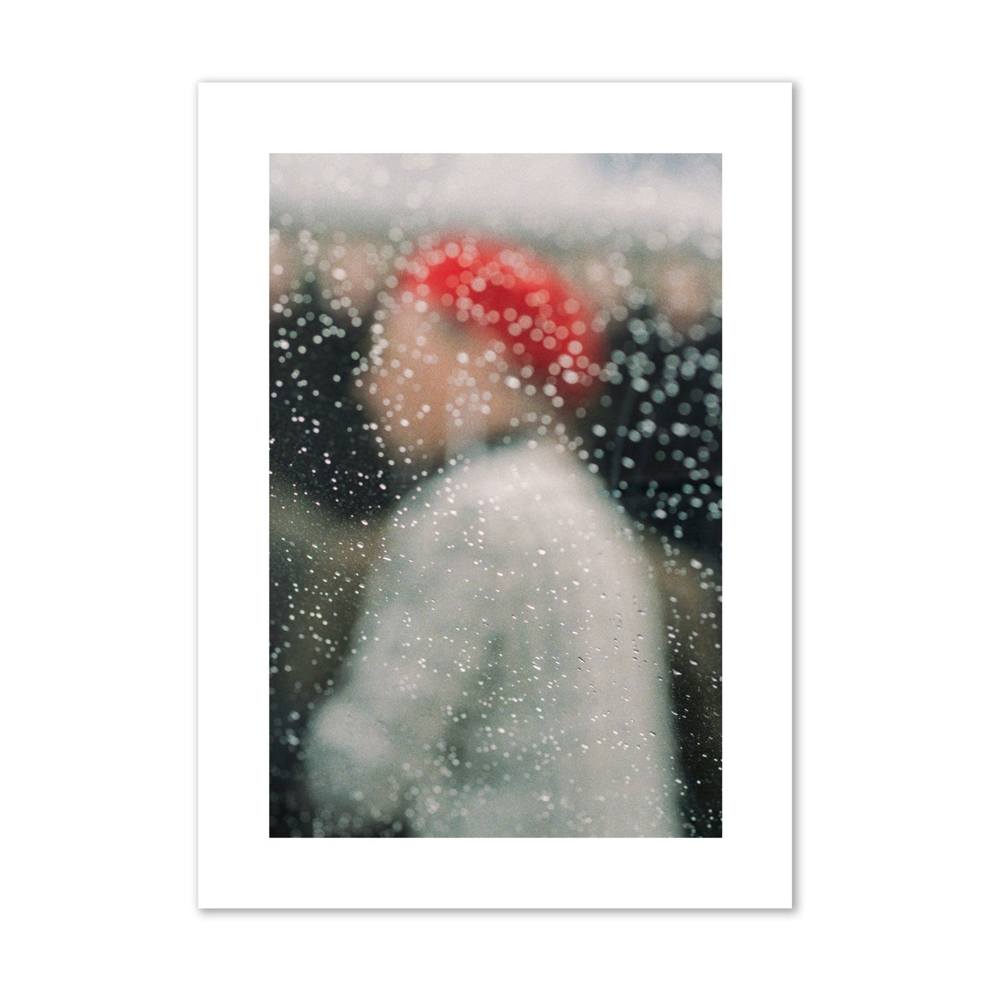 Fine art photograph of a woman with a red hat through raindrops on a window, archival pigment print, giant size, print.