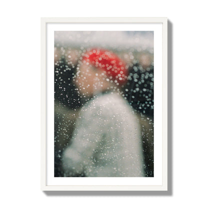 Fine art photograph of a woman with a red hat through raindrops on a window, archival pigment print, giant size, white frame.