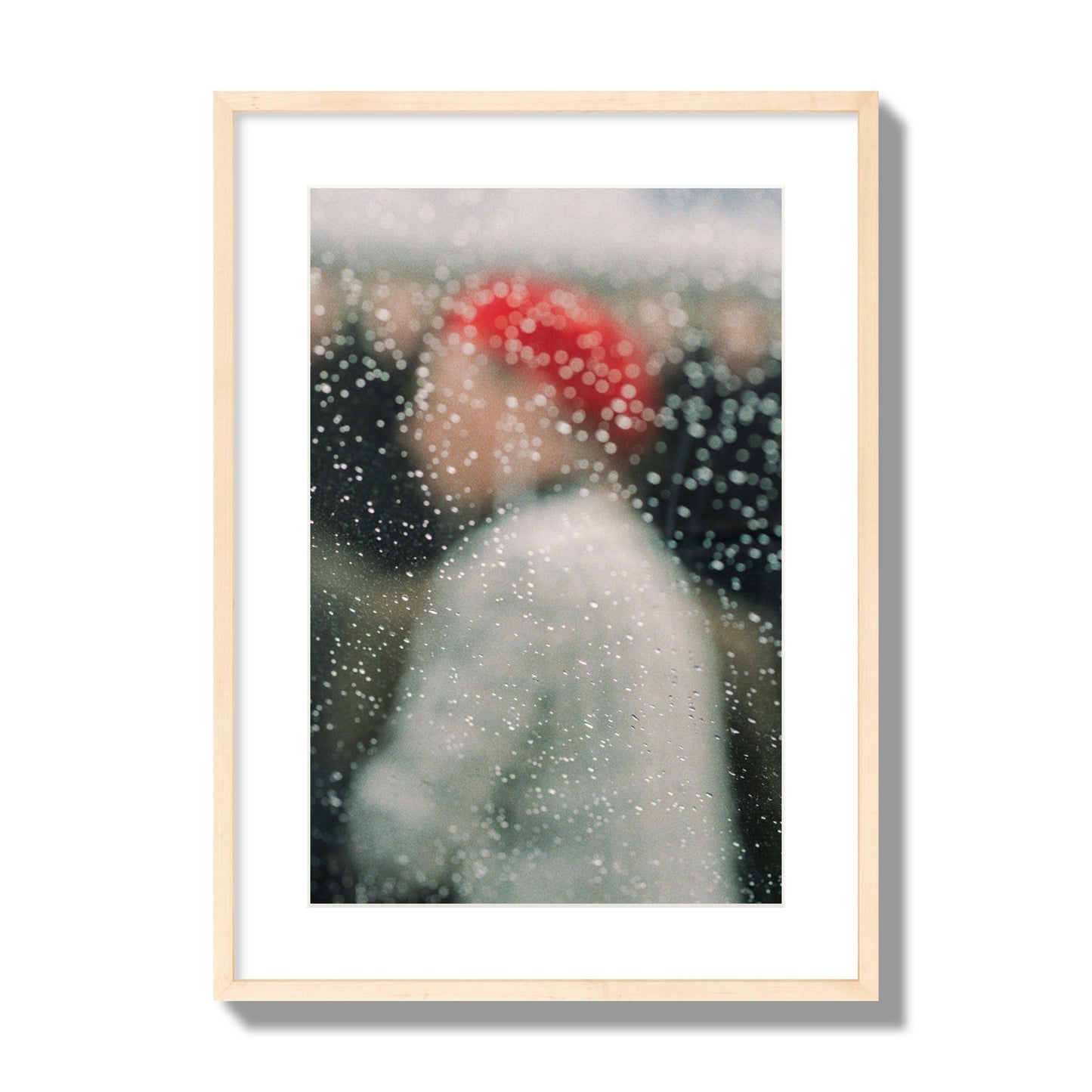 Fine art photograph of a woman with a red hat through raindrops on a window, archival pigment print, large size, natural wood frame.