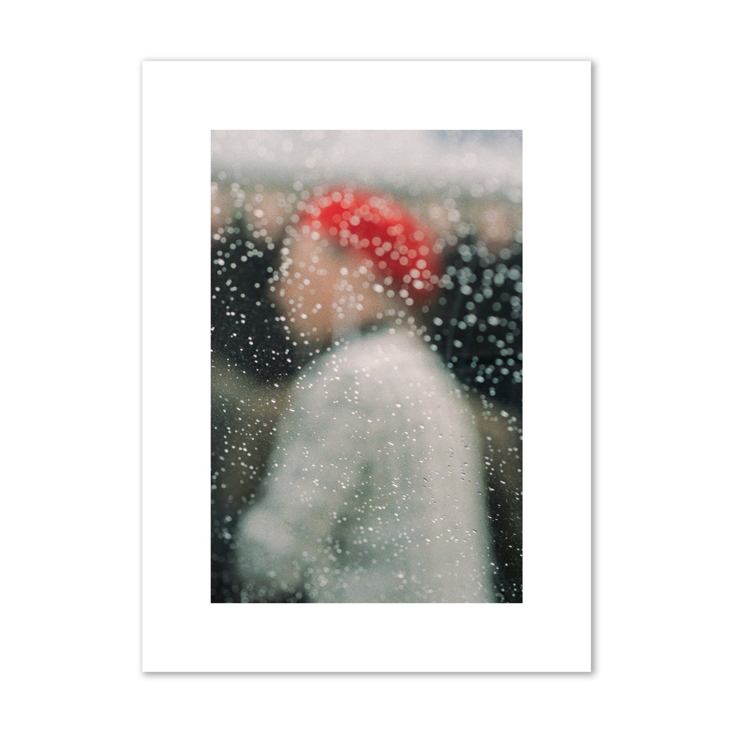 Fine art photograph of a woman with a red hat through raindrops on a window, archival pigment print, medium size, print.