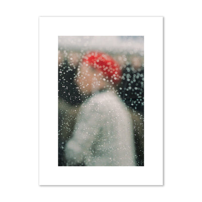 Fine art photograph of a woman with a red hat through raindrops on a window, archival pigment print, medium size, print.