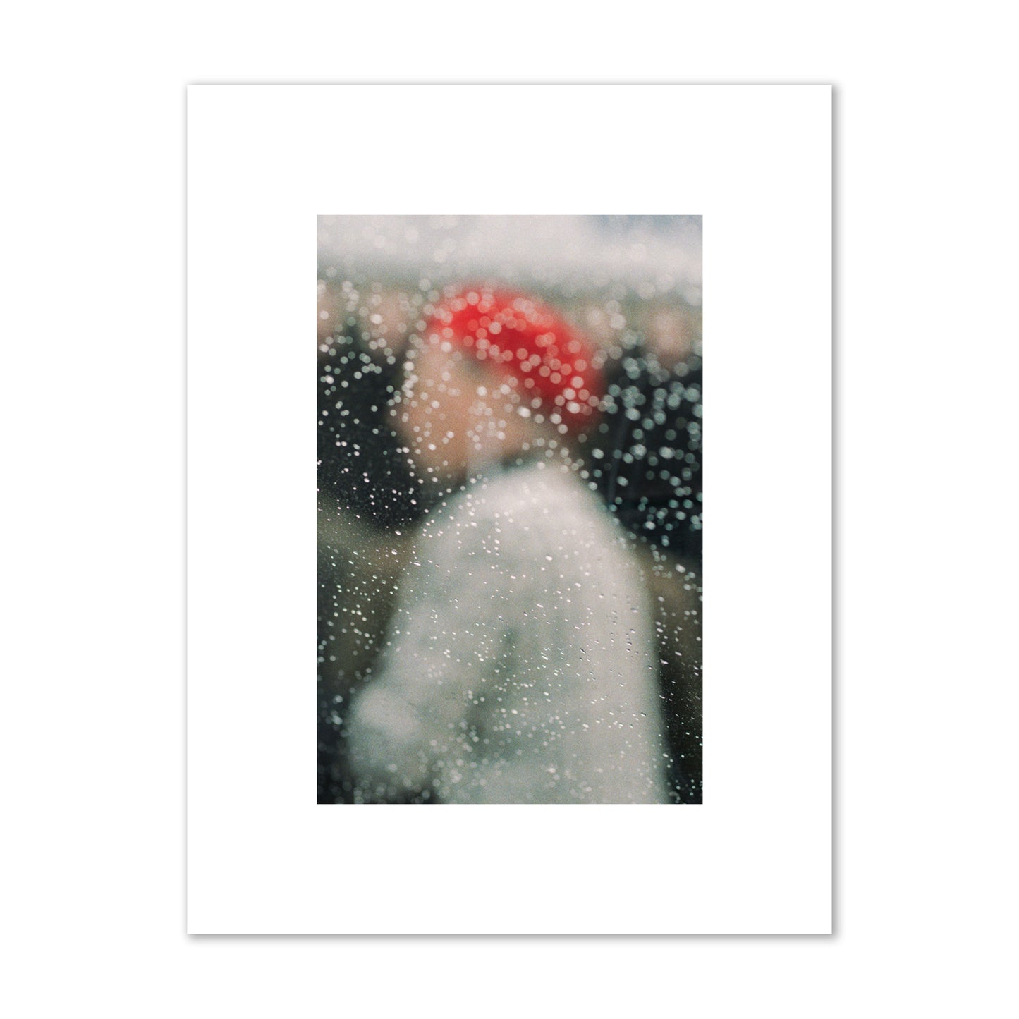 Fine art photograph of a woman with a red hat through raindrops on a window, archival pigment print, small size, print.
