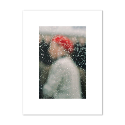 Fine art photograph of a woman with a red hat through raindrops on a window, archival pigment print, small size, print.