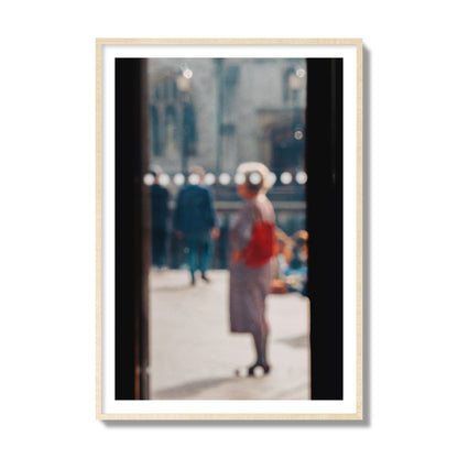 Fine art photograph of a blurred street scene with people and a storefront, archival pigment print, collector size, natural wood frame.