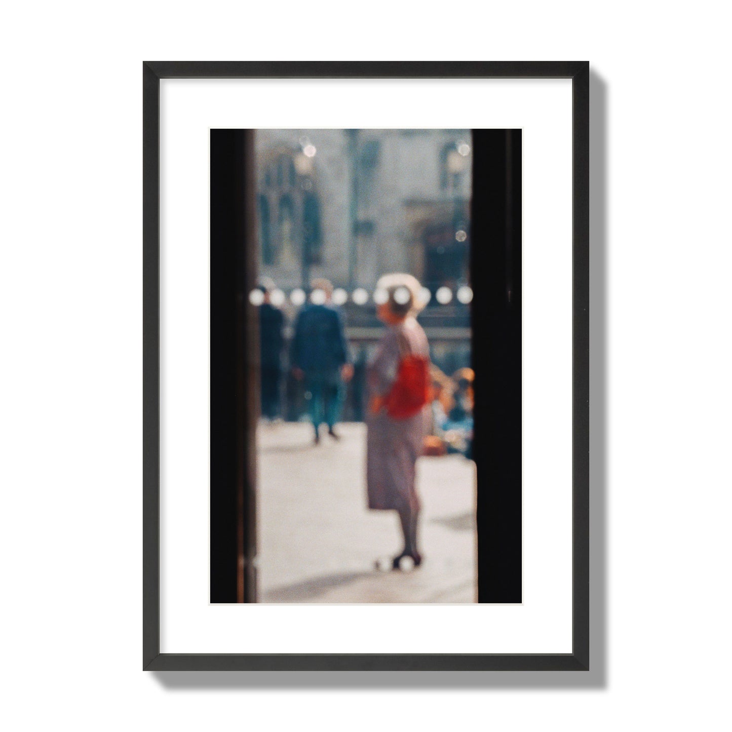 Fine art photograph of a blurred street scene with people and a storefront, archival pigment print, large size, black frame.